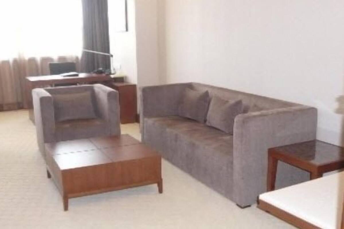 Suite Deluxe | Área de sala de estar | Televisión, computadora y películas con cargo