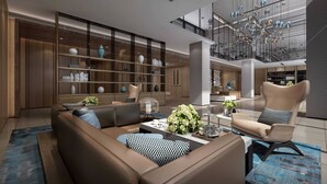 A spacious living area with a modern sofa, a coffee table, and a bookshelf. - Fairfield by Marriott Ningbo Yinzhou (Ningbo)
