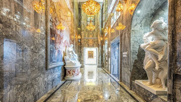 A marble-floored hallway with statues and chandeliers. - AC Embassy Hotel (Beijing)