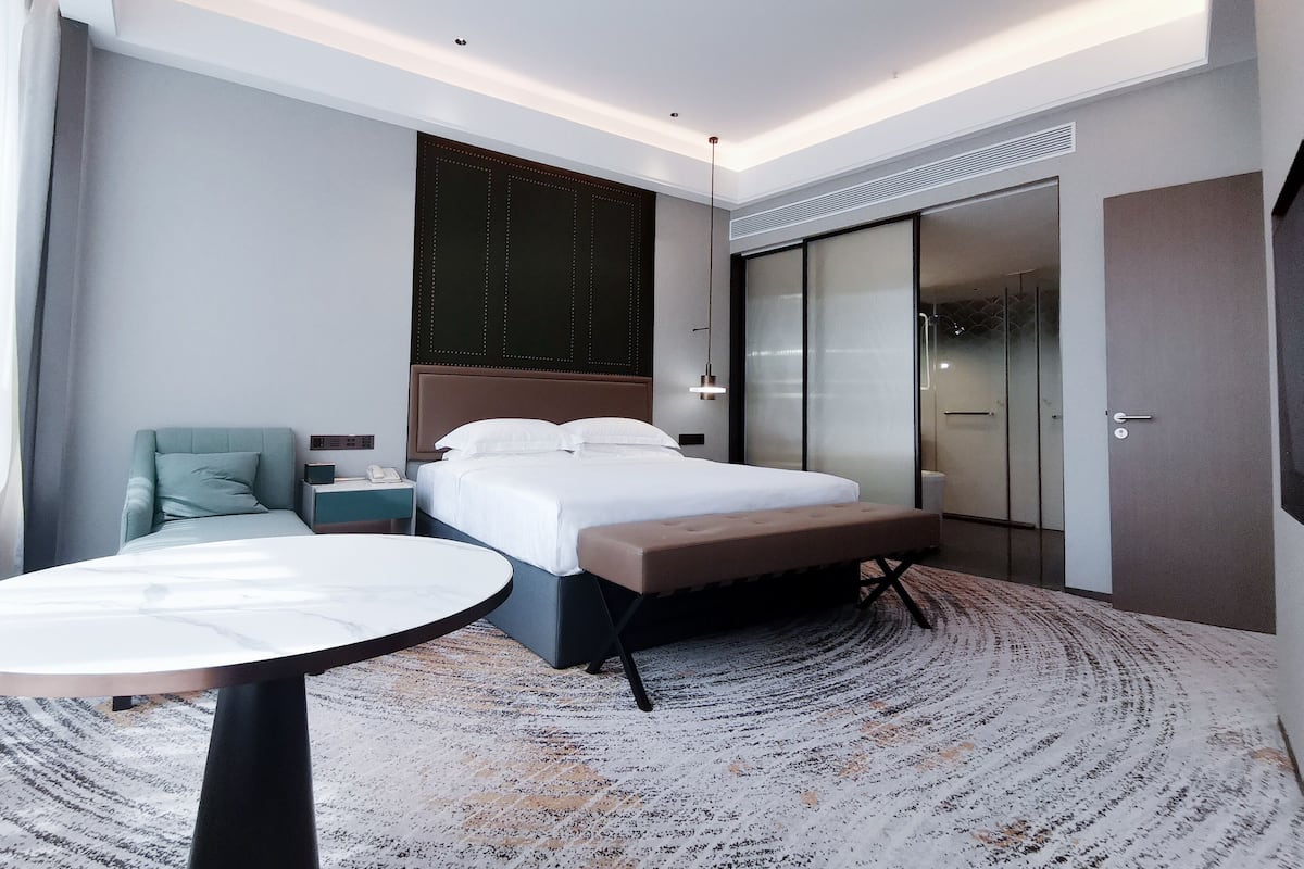 Una habitación de hotel moderna con cama, escritorio y silla.