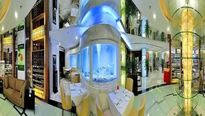 A spacious indoor area with a large aquarium, seating arrangements, and various shops. - Shenzhen Liyuan Hotel (Shenzhen)