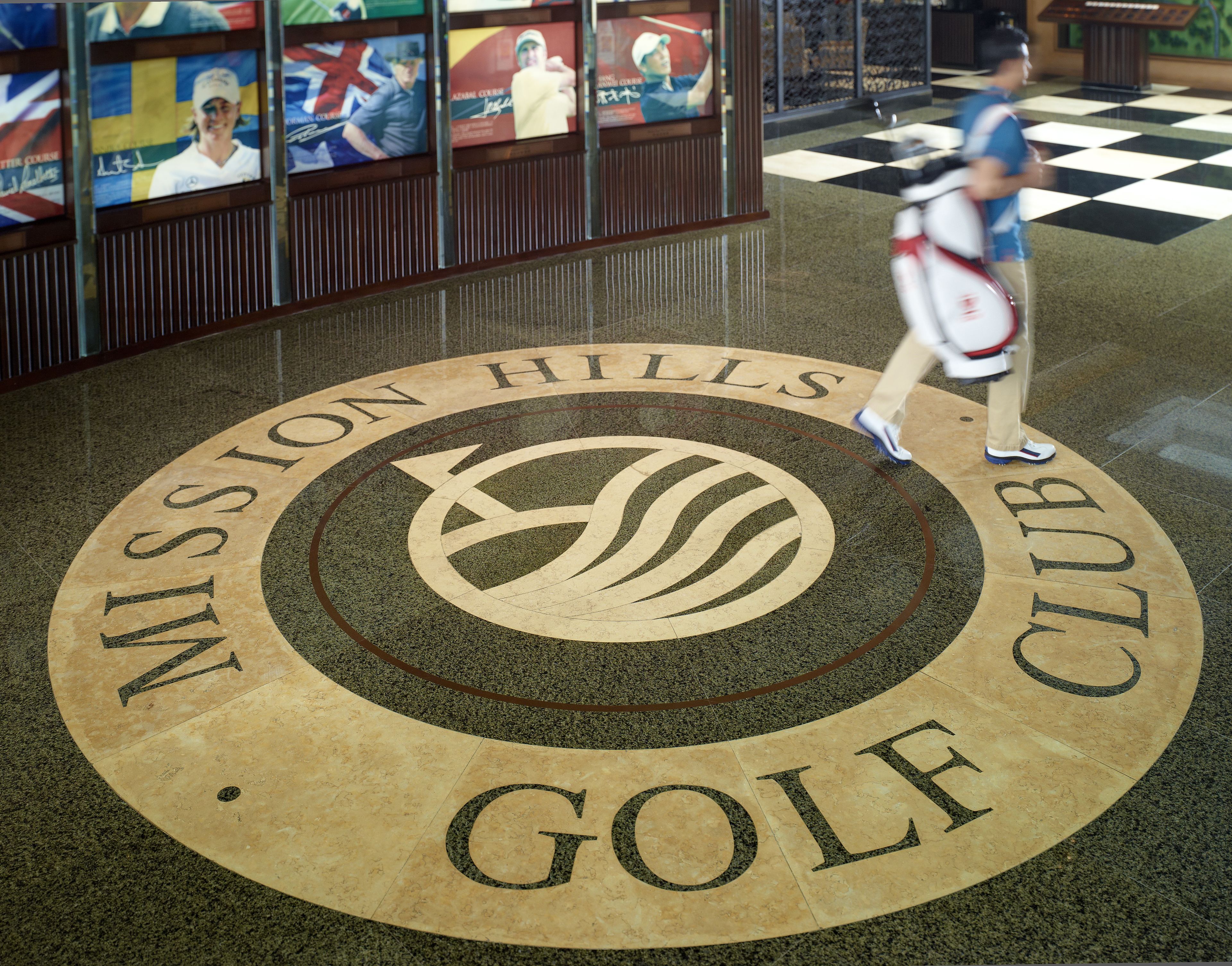Un emblema circular con la inscripción "Mission Hills Golf Club" sobre un piso pulido.