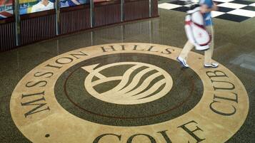 Un emblema circular con la inscripción "Mission Hills Golf Club" sobre un piso pulido.