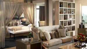 A spacious living area with a sofa, a coffee table, and a bookshelf filled with decorative items. - Mission Hills Resort Shenzhen (Shenzhen)