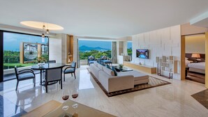 A modern living room with a large sofa, dining area, and a TV mounted on the wall. - Mission Hills Resort Shenzhen (Shenzhen)