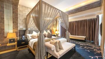 A four-poster canopy bed with a nightstand, lamp, and a bench in a modern hotel room.