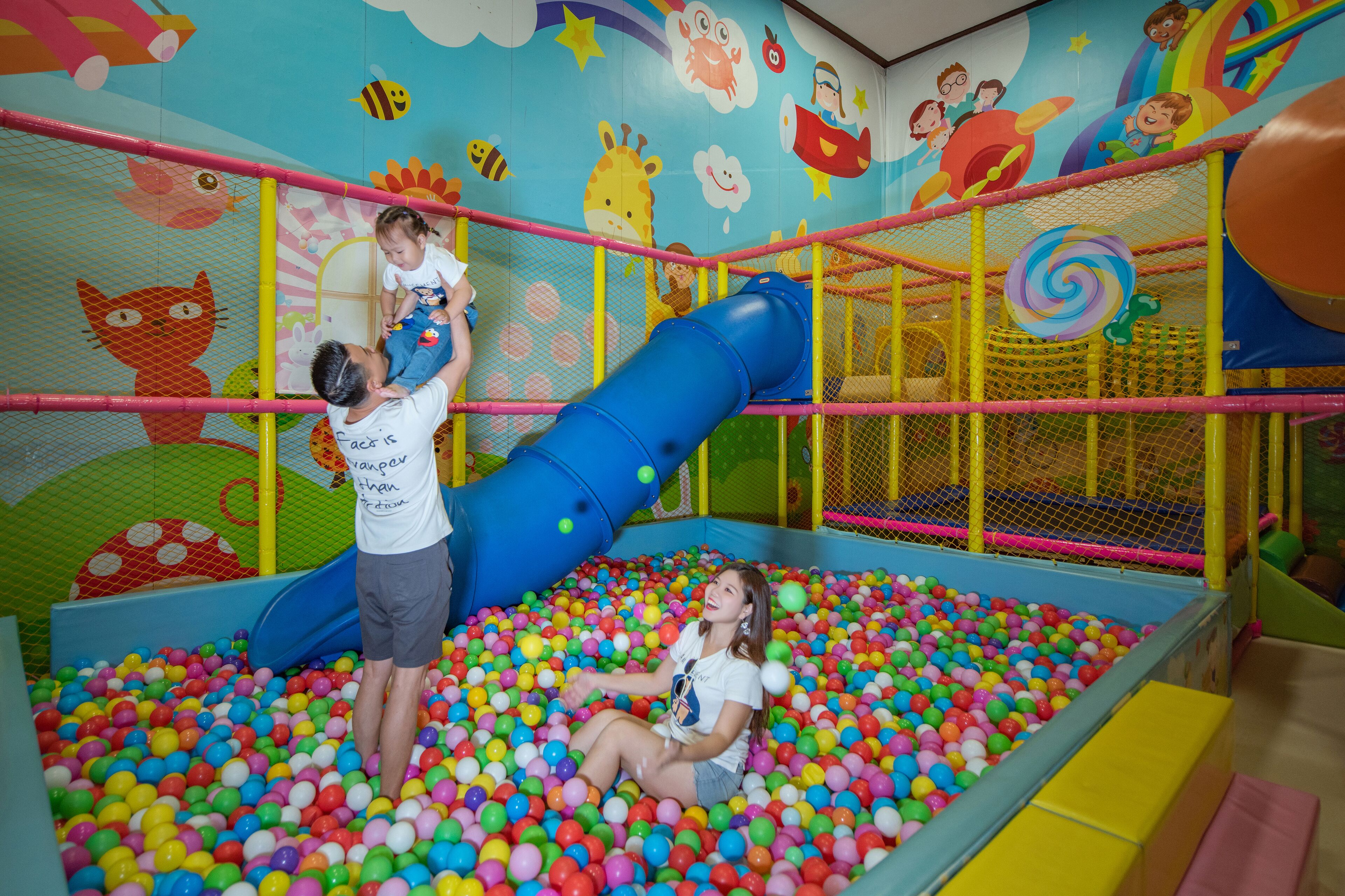 A play area with a ball pit, a slide, and a netted play structure.