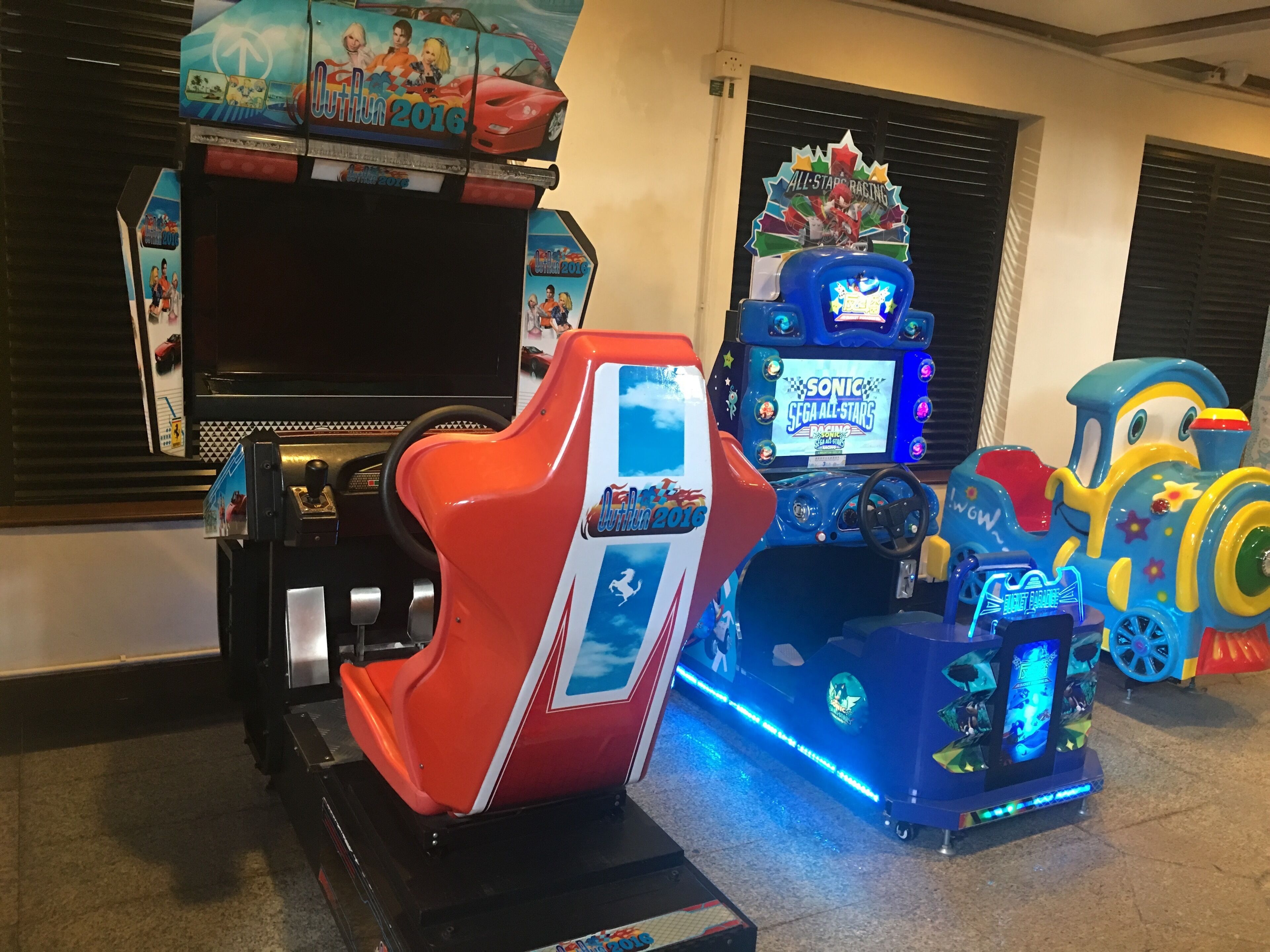 A row of arcade machines, including Outrun 2016, Sonic, and a train-themed game.