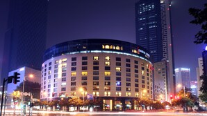 A hotel with a curved facade, multiple floors, and illuminated windows. - Nanjing Central Hotel (Nanjing)