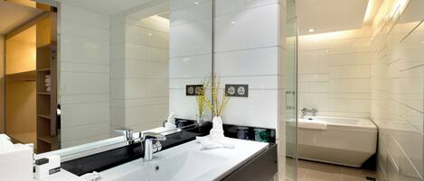 Un bagno moderno con uno specchio grande, due lavabi, cabina doccia in vetro e doccia a pavimento.