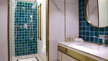 Ein Badezimmer mit Dusche, Waschbecken und Spiegel.