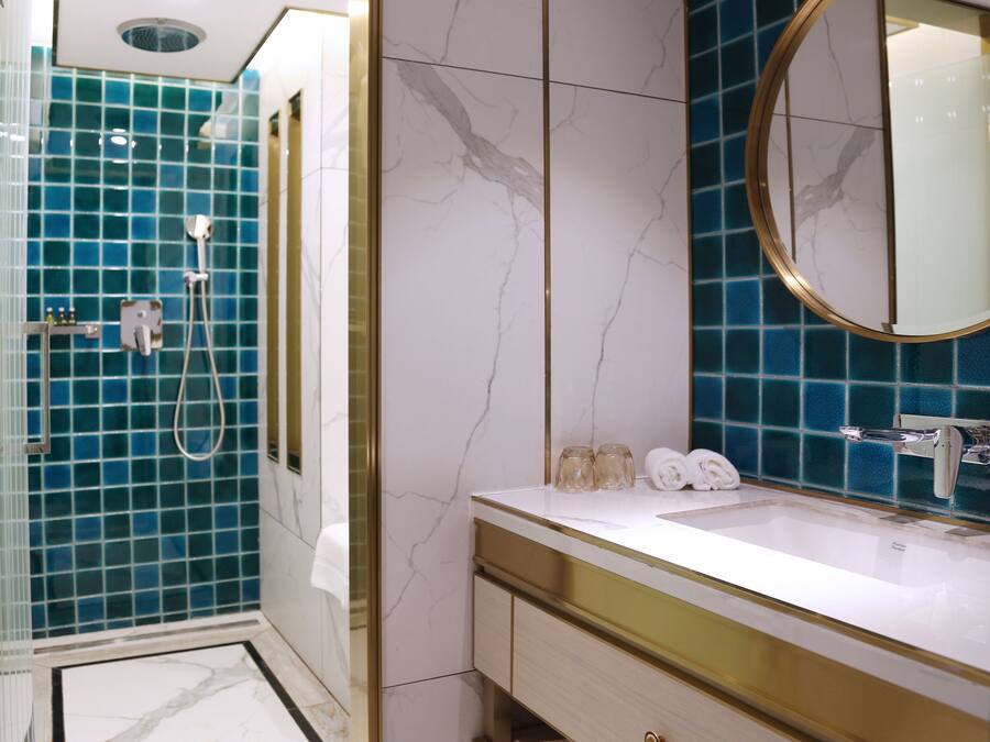 Ein Badezimmer mit Dusche, Waschbecken und Spiegel.