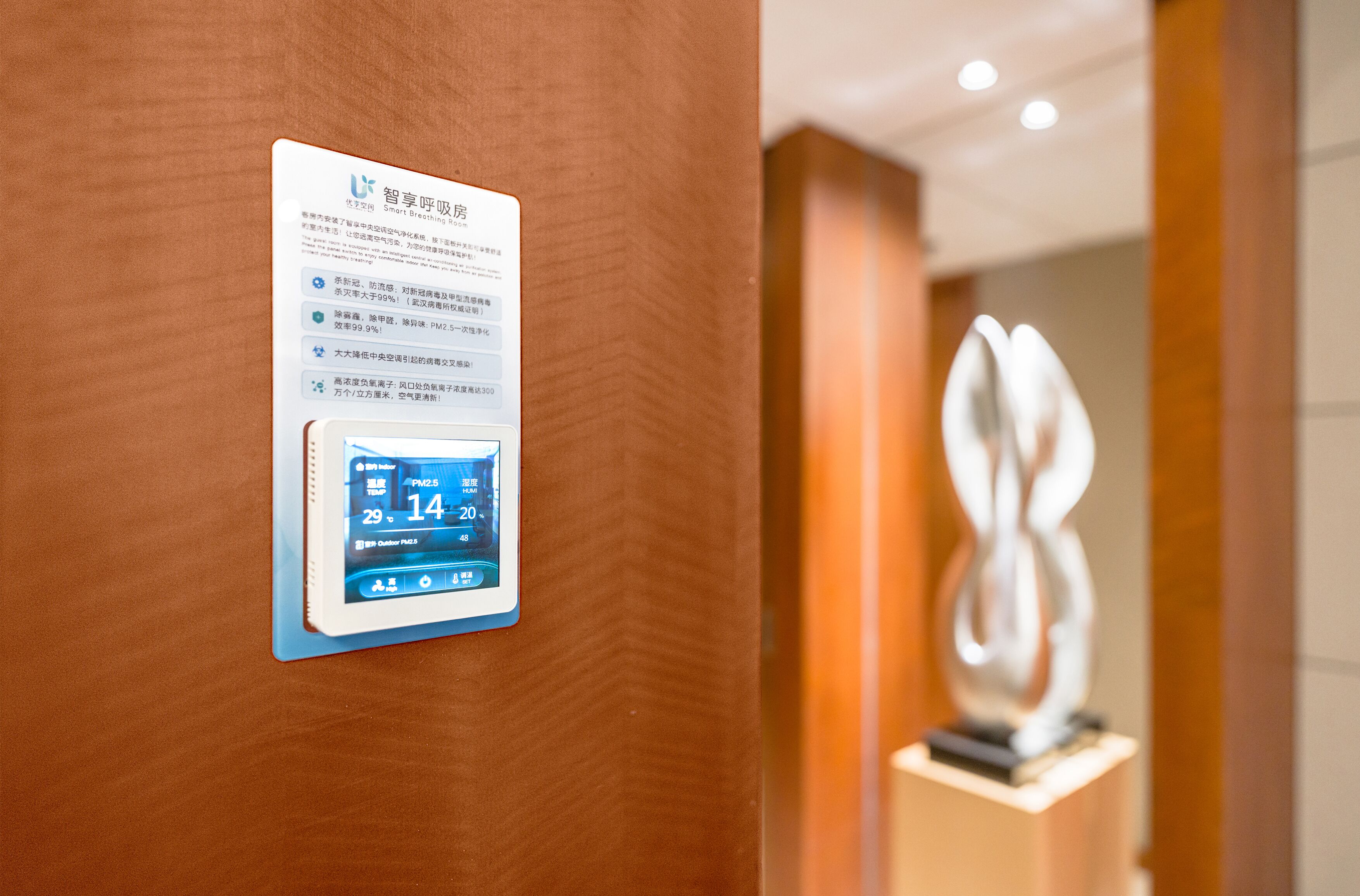 A digital display on a wall with text and a weather forecast.
