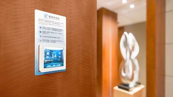 A digital display on a wall with text and a weather forecast.