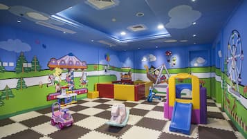 Children can play and explore in this colorful playroom with a checkered floor, carousel, slide, and climbing area.