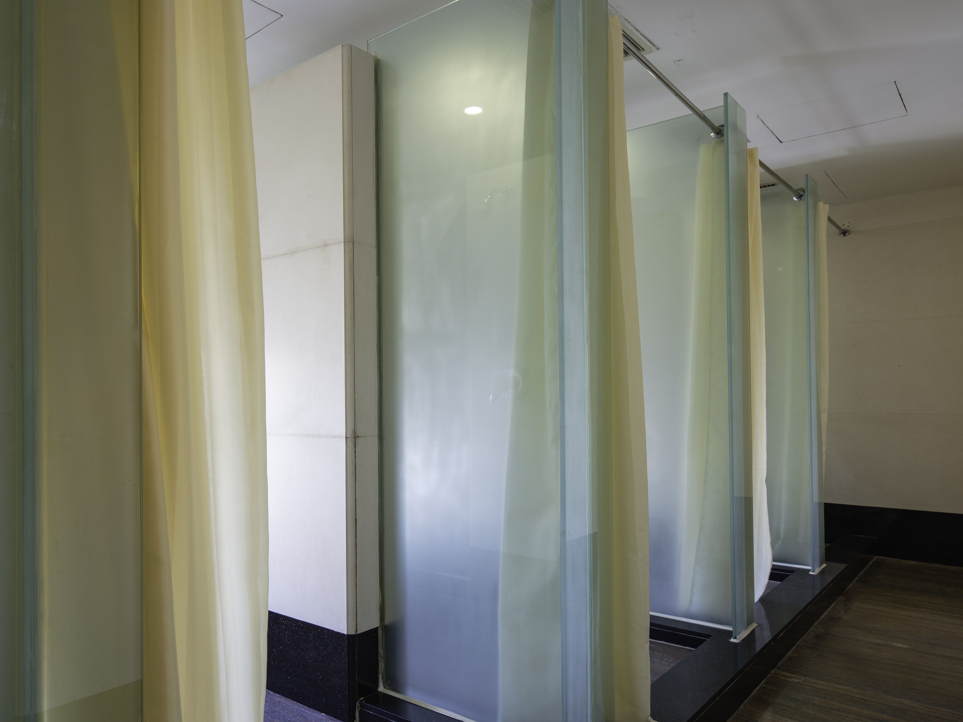 A corridor with frosted glass partitions and a wooden floor.