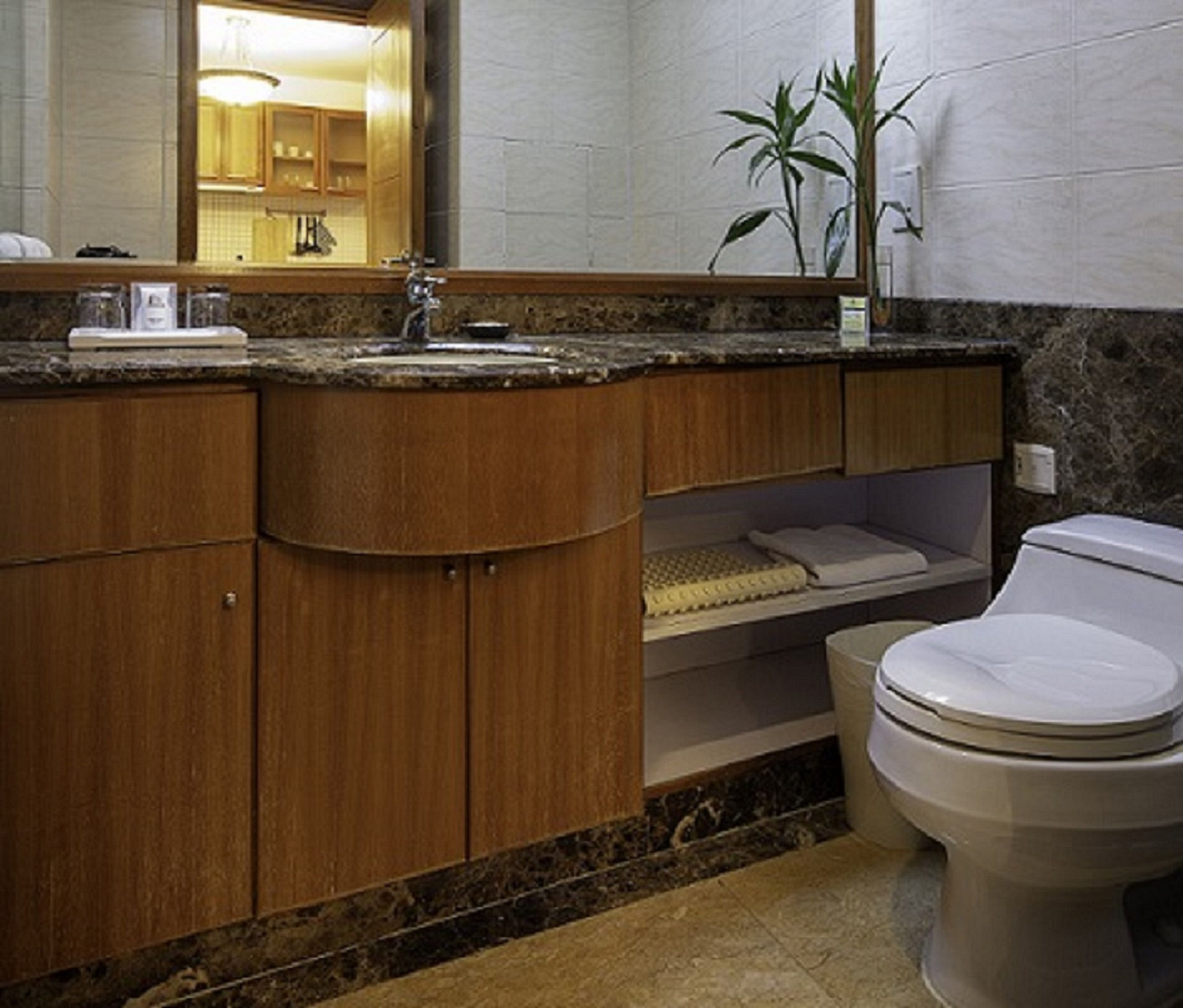 Ein Badezimmer mit einem Holzwaschtisch, einem Waschbecken, einer Toilette und einem Spiegel.