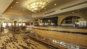 A spacious lobby with a curved reception desk, a large chandelier, and a patterned carpet. - Dalian Asia Pacific Service Apartment (Dalian)