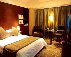 A hotel room with a large bed, a desk with a chair, a television, and a window with curtains. - Fortune Bond Hotel (Ningbo)