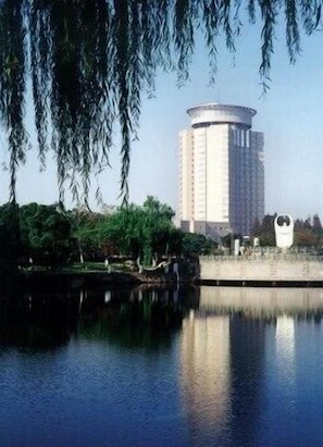 A cylindrical building with a reflective water surface in front. - Fortune Bond Hotel (Ningbo)