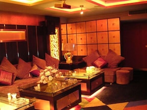A cozy lounge area with a sofa set, a coffee table, and a decorative lamp. - Ningbo Hotel (Ningbo)