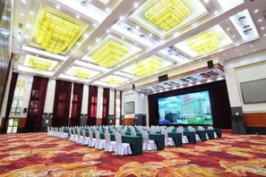 A conference room with rows of tables, a large screen, and a patterned carpet. - Liuzhou Hotel (Liuzhou)