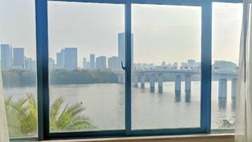 A view from a window overlooking a river with a bridge and a city skyline in the background.