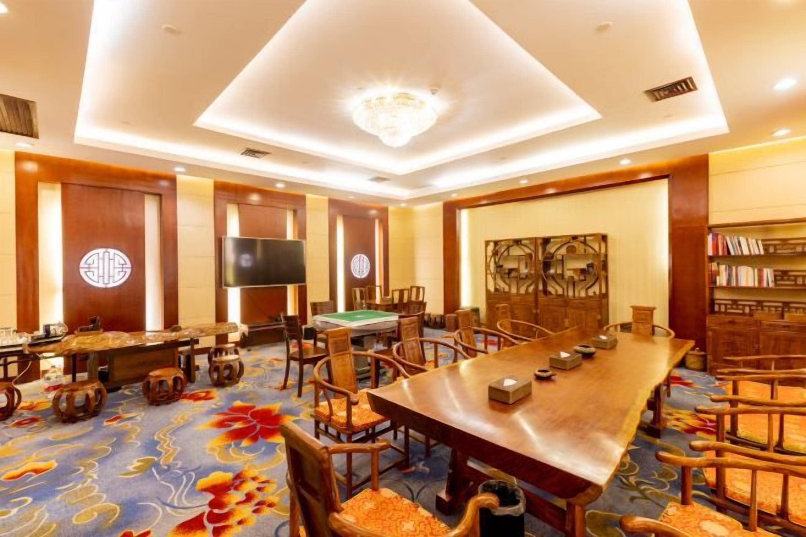 A conference room with a long table, chairs, a pool table, and a television.