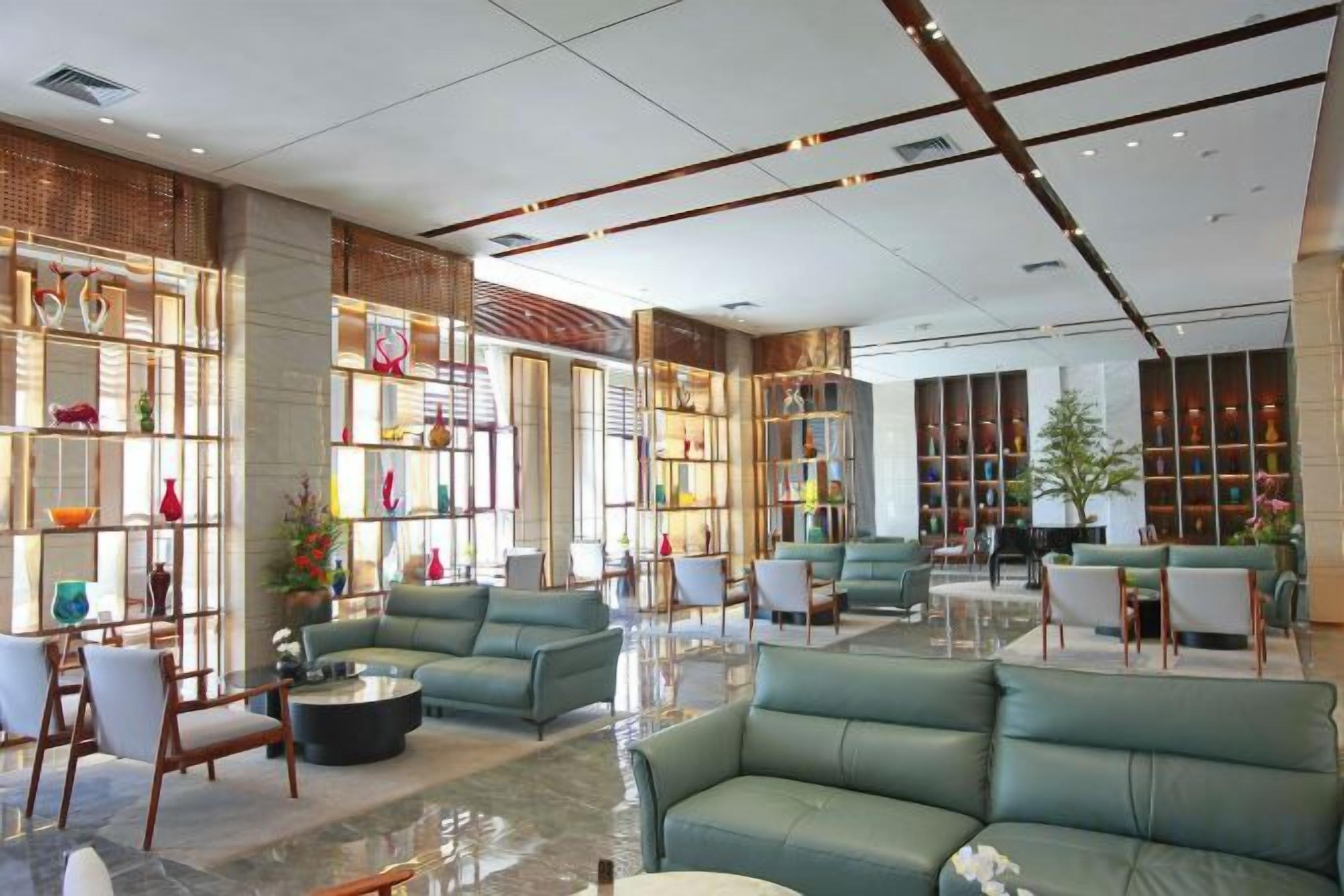 A spacious lobby with seating areas, a coffee table, and a bookshelf.