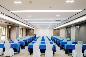 A conference room with rows of tables and chairs, equipped with water bottles and nameplates. - Regal Hotel (Guiyang)