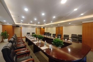 A conference room with a long table, multiple chairs, and potted plants. - Regal Hotel (Guiyang)