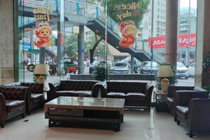 A lobby with leather sofas, a glass coffee table, and a staircase in the background. - Regal Hotel (Guiyang)