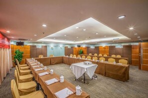 A conference room with long tables, chairs, and a white table with a laptop. - Regal Hotel (Guiyang)