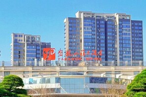 Un hotel de varios pisos con un diseño moderno, que destaca un logotipo y señalización.