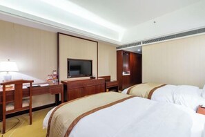 A hotel room with two beds, a desk, a television, and a wardrobe. - Tianlong Hotel (Changsha)