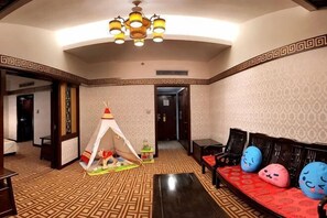 A hotel lobby with a patterned floor, a tent, a sofa with colorful cushions, and a chandelier. - Guilin Park Hotel (GUILIN)