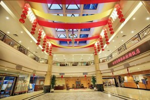 A multi-level atrium with a central open space, railings, and a reception desk. - Guilin Park Hotel (GUILIN)