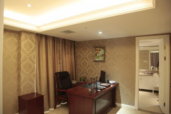 A room with a desk, chair, and a door leading to a bathroom. - Kaiyuan International Hotel (Jiaxing)