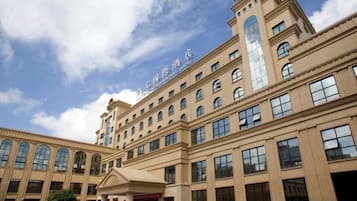 A large hotel building with multiple floors, a prominent entrance, and a clear sky.