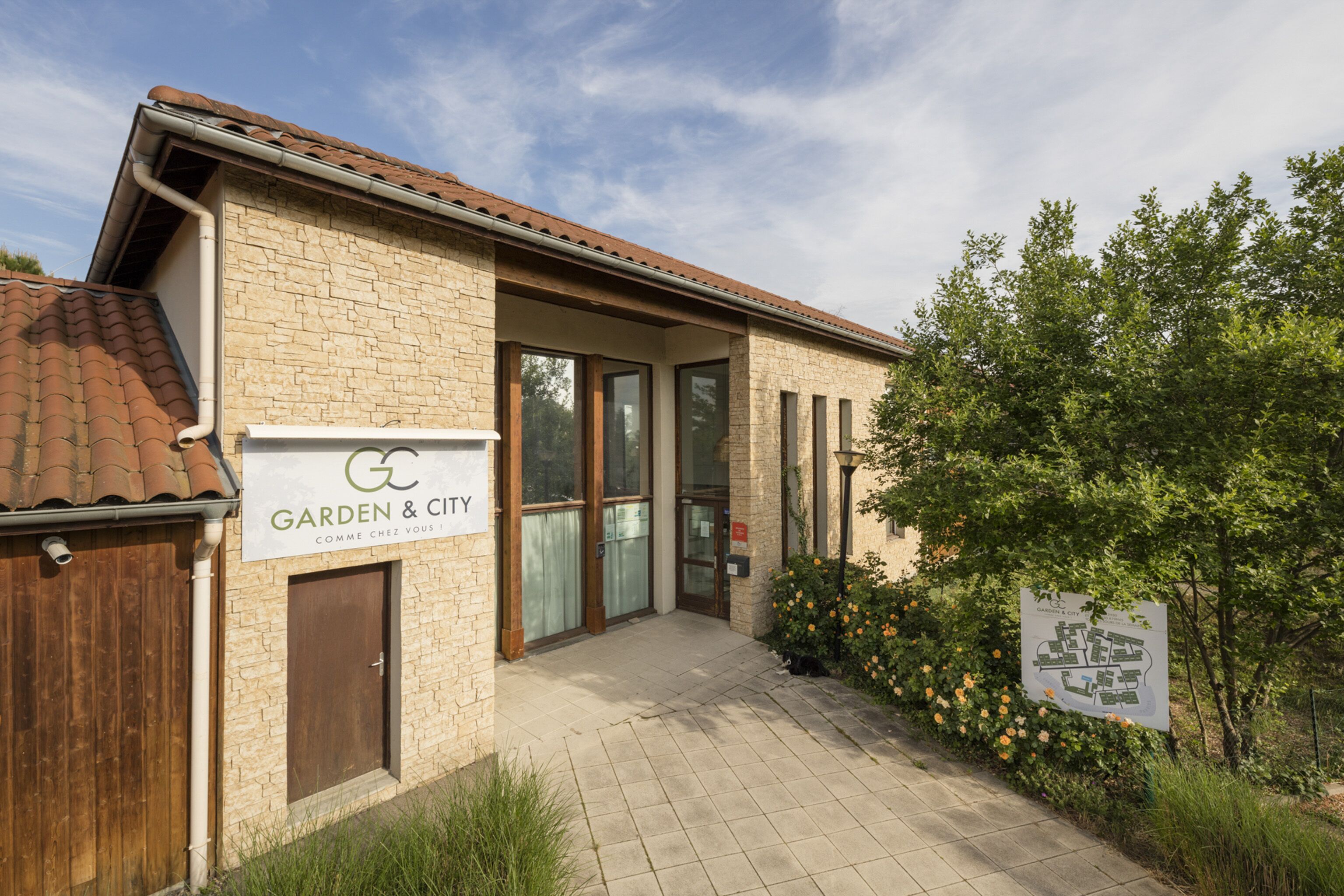 A building with a sign reading "Garden & City" and a brick facade.
