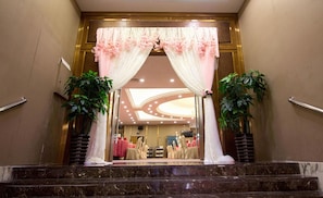 A hotel entrance with a marble staircase, a reception desk, and a seating area with tables and chairs. - Celeste Palace Hotel (Jiangmen)