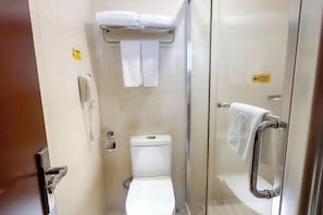 A small, compact bathroom with a toilet, a glass shower enclosure, a towel rack, and a hand dryer. - Celeste Palace Hotel (Jiangmen)
