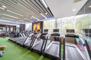 A gym with treadmills, exercise bikes, and a green carpeted floor. - Maritim Hotel Taicang Garden (Suzhou)