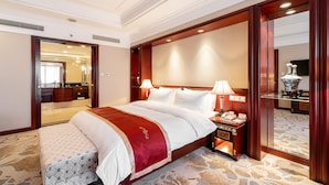 Une chambre d’hôtel avec un grand lit, des lampes de chevet, une table de nuit et un miroir.