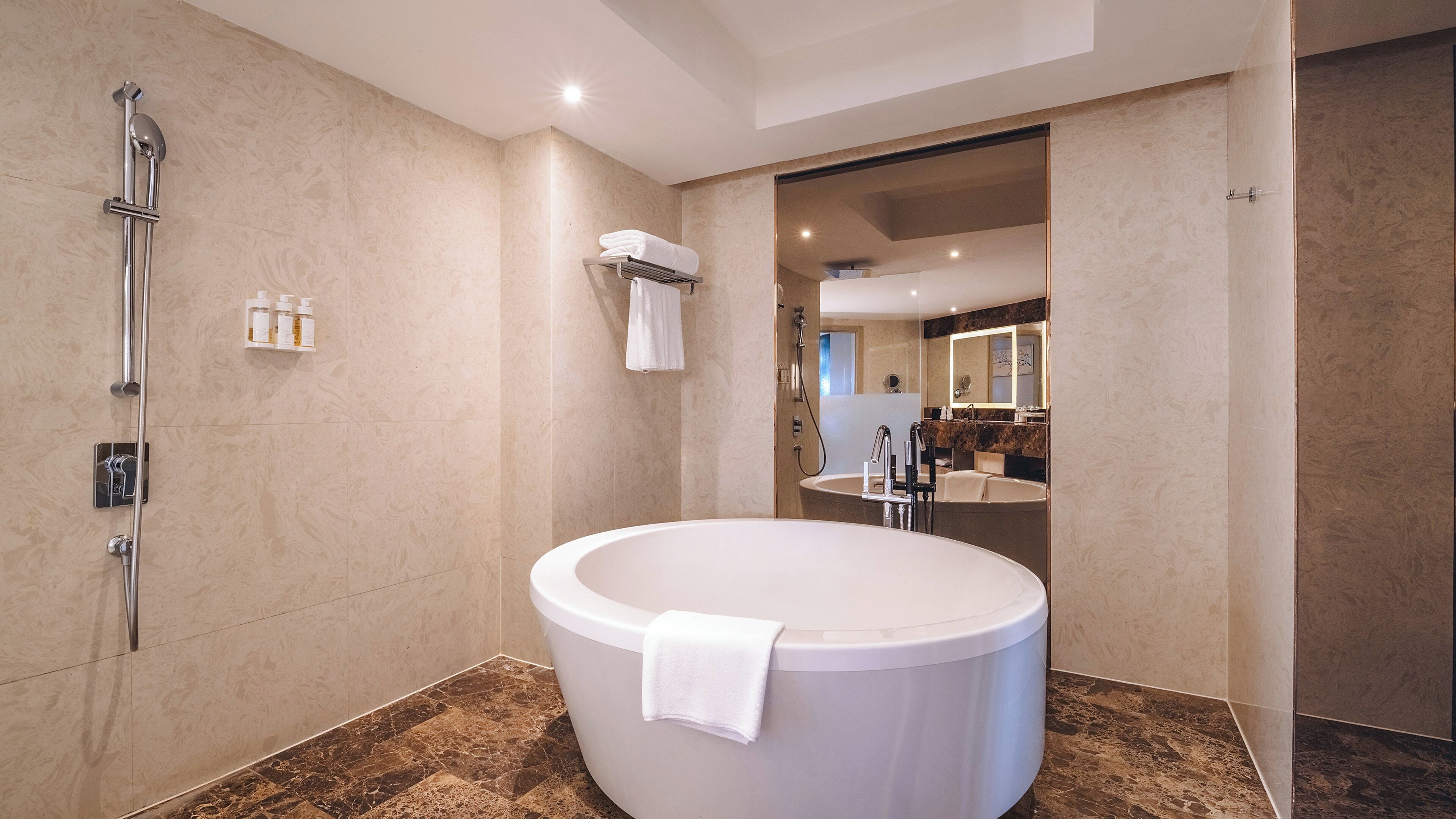 A modern bathroom with a freestanding bathtub, a walk-in shower, and a vanity with a large mirror.