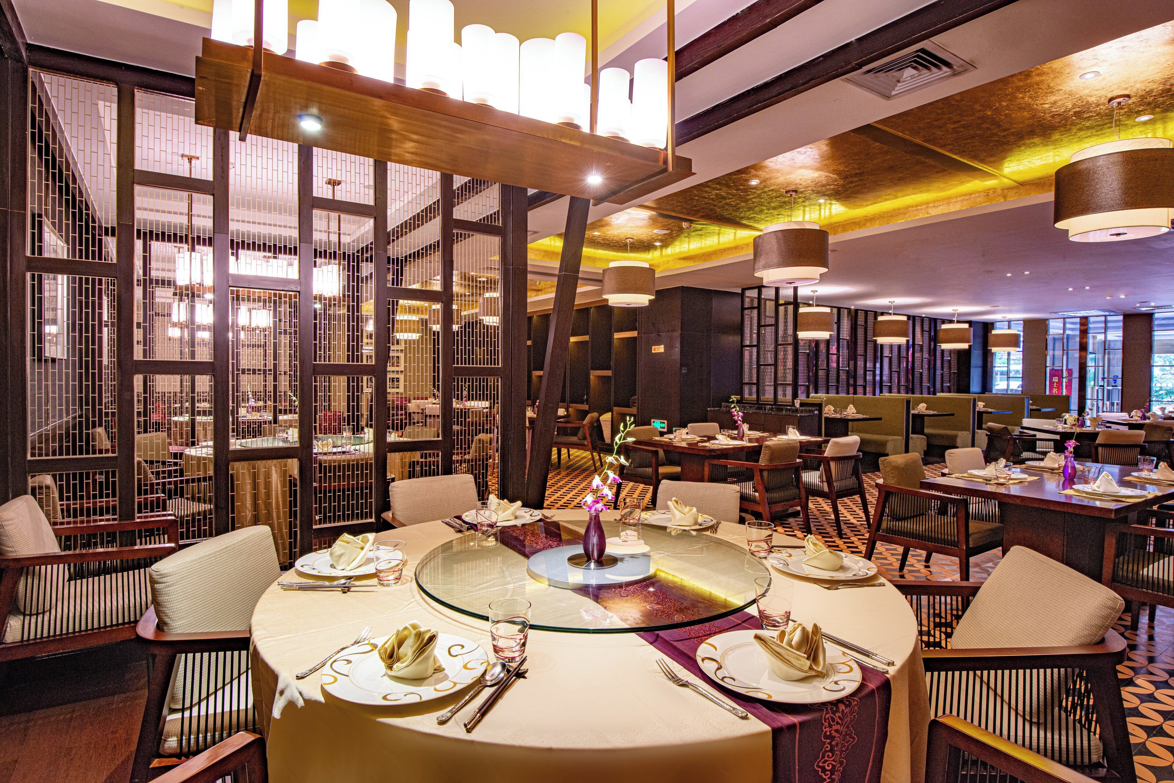 Un restaurant avec des tables et des chaises rondes, et un décor intérieur moderne.