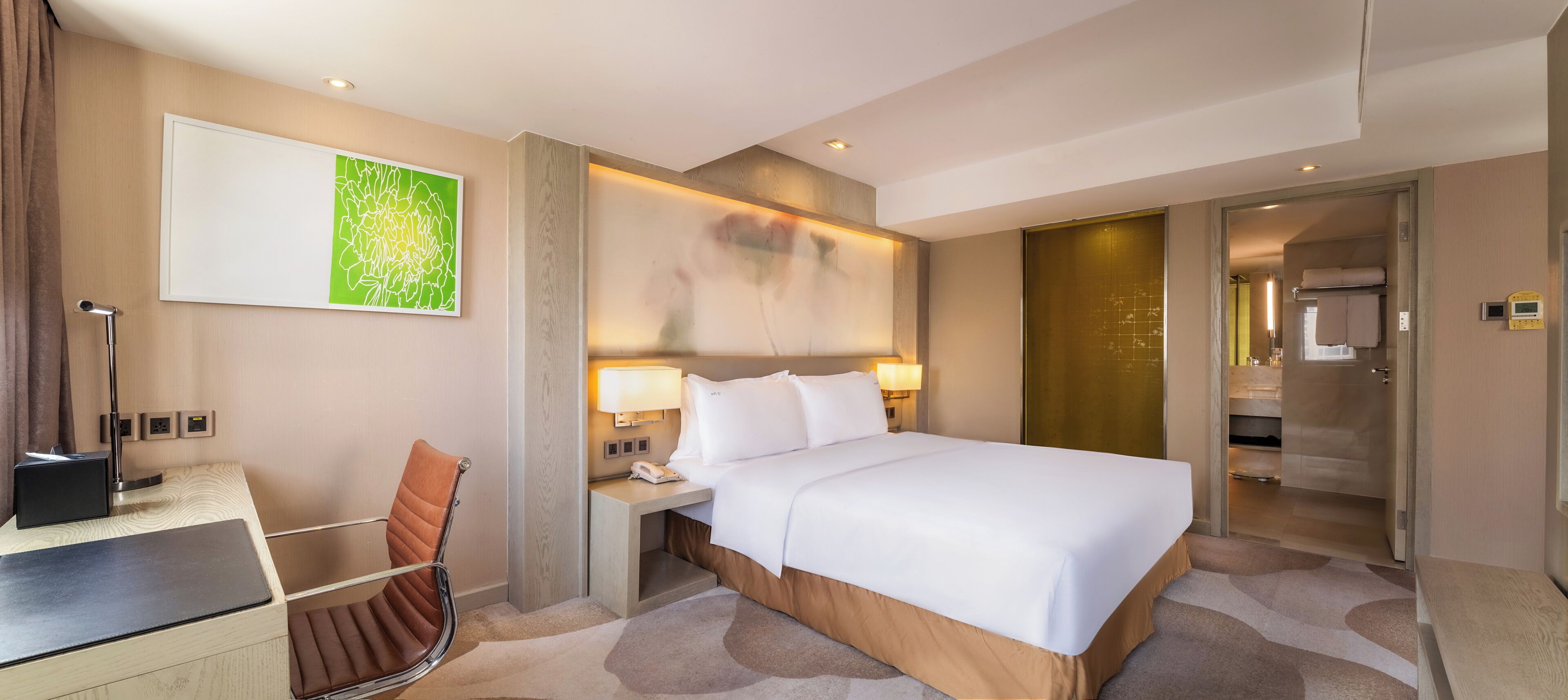 Una camera d'albergo moderna con un letto grande, comodini, una scrivania e una sedia.