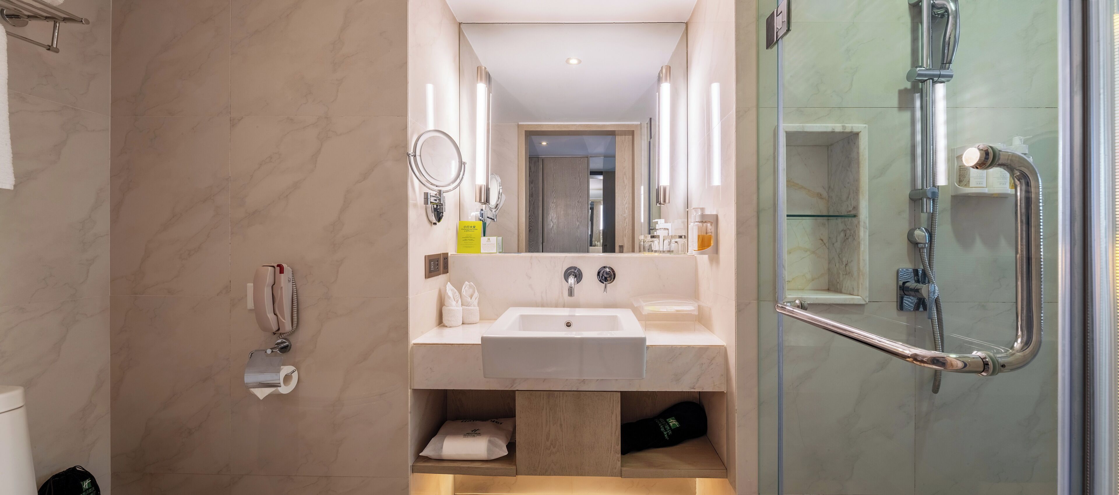 A modern bathroom with a glass-enclosed shower, a sink, and a mirror.