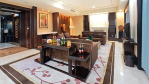 A modern living room with a sofa set, a coffee table with beverages, a TV, and a fireplace. - Holiday Inn Mudanjiang by IHG (Mudanjiang)