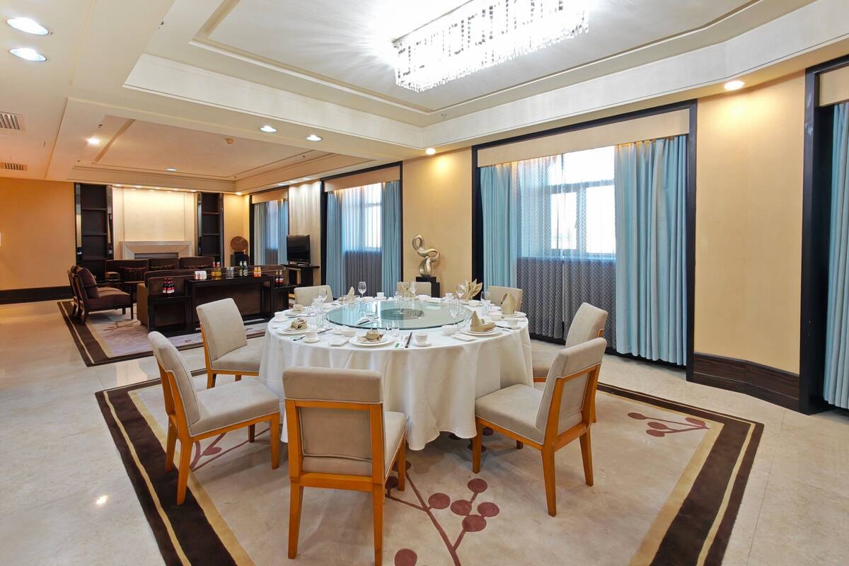 A conference room with a round table, chairs, and a television.
